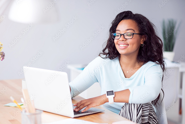 A woman sitting at a table with a laptop.