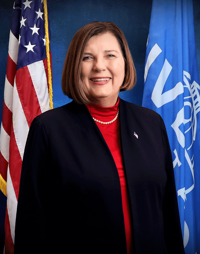 A man in front of a flag.