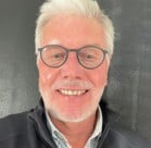 A man with white hair and glasses.