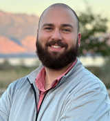 A man with a beard smiling.