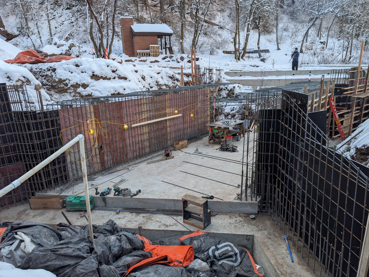 A construction site with a fence and snow.