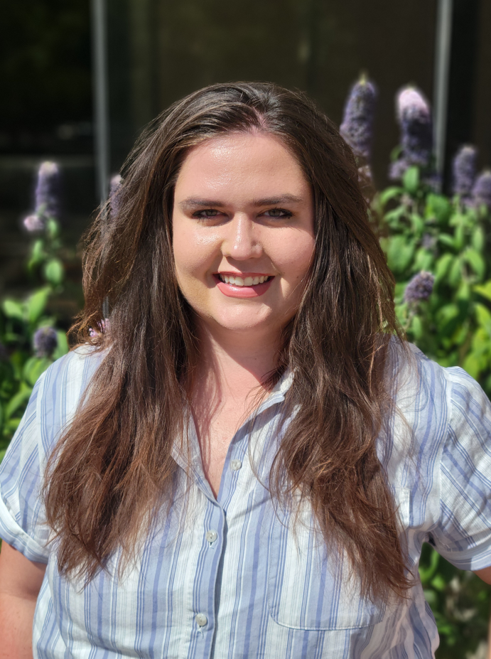A person with long hair smiling.