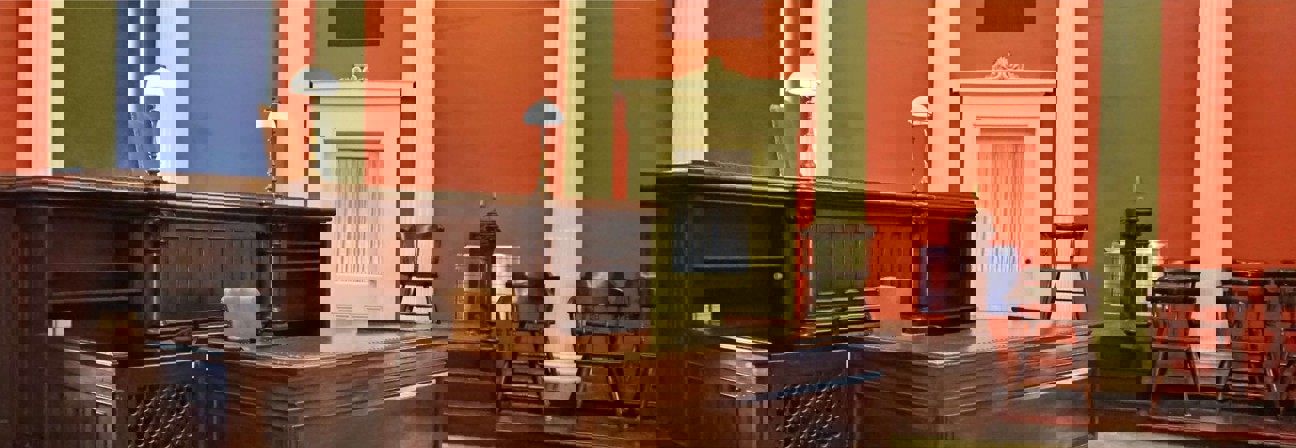 A room with a desk and chairs.