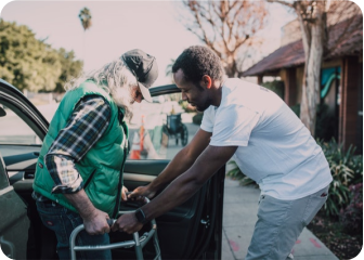 A man pushing another man in a car.