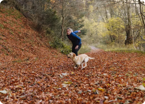 A man and a dog in a forest.