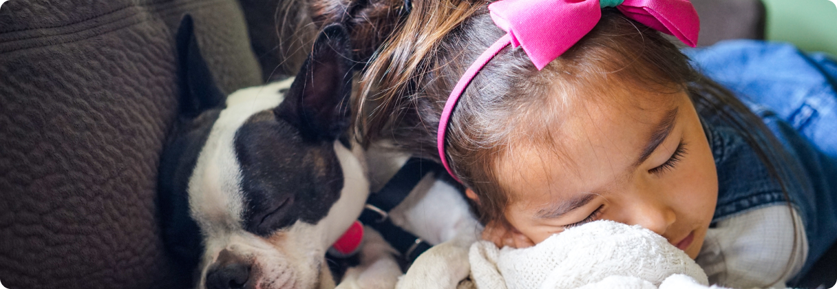 A girl sleeping with a dog.