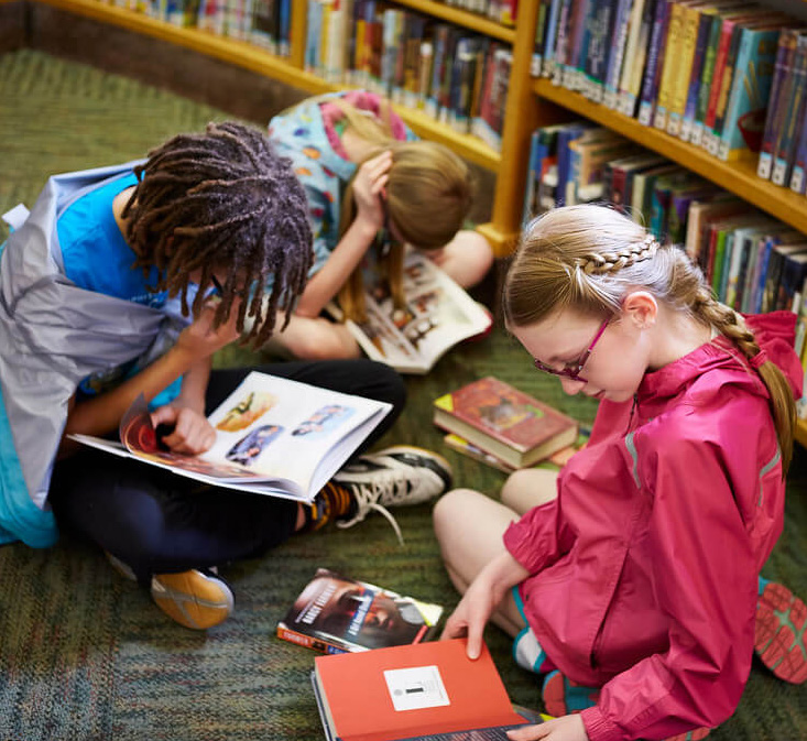 A group of children reading books.