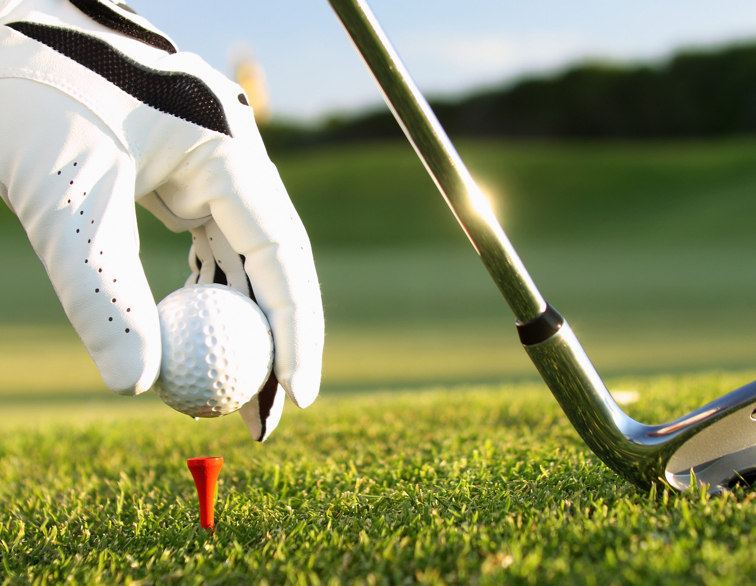 A golf club hitting a ball.