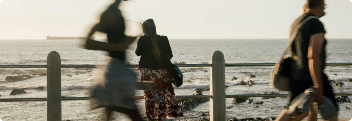 A group of people walking on a beach.