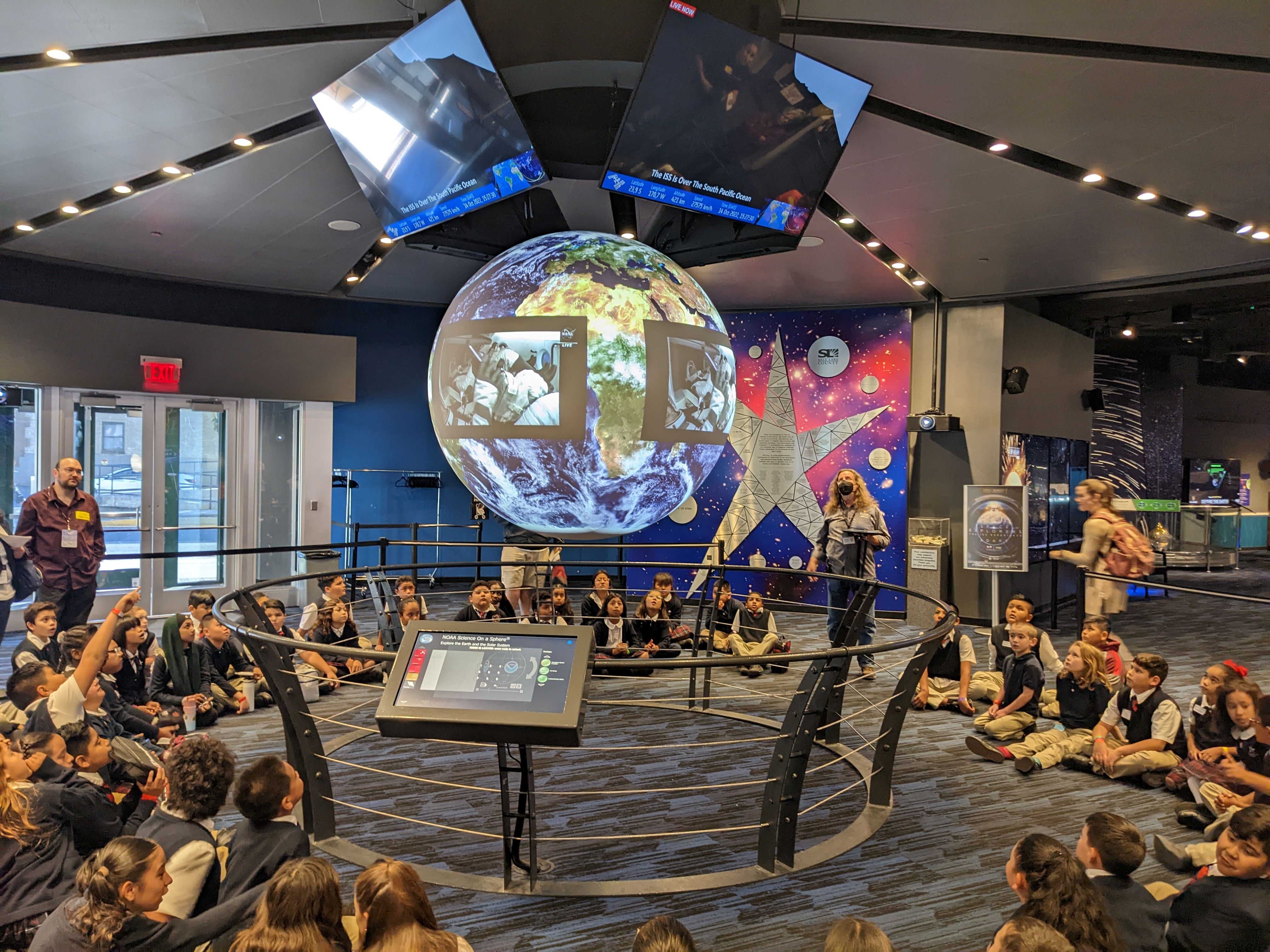 A group of people sitting on a stage with a globe in the front.