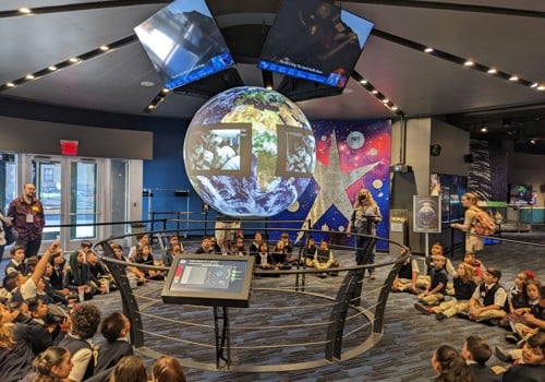 A group of people sitting on a stage with a globe in the front.
