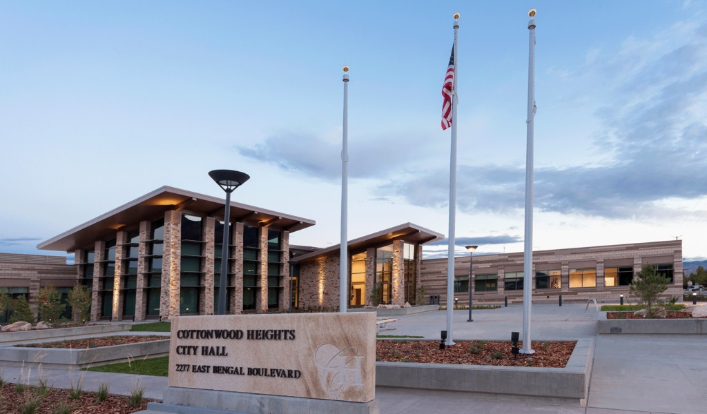 A building with a flag pole and a sign in front of it.