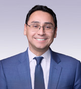 Ross I. Romero wearing a blue suit and tie.