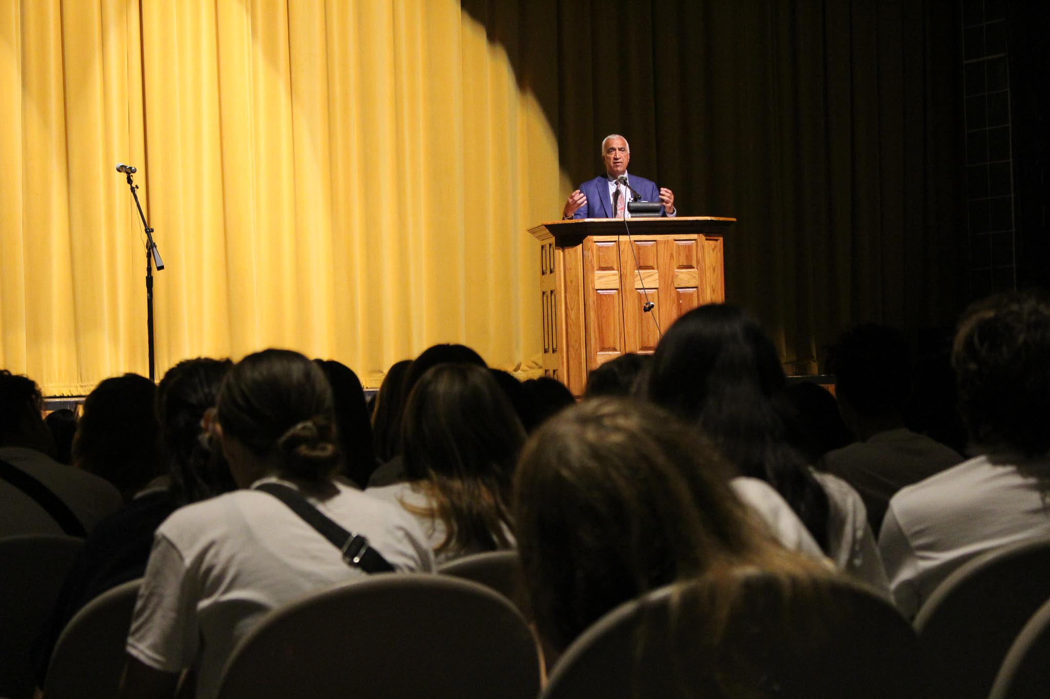 A person standing at a podium in front of a crowd of people.