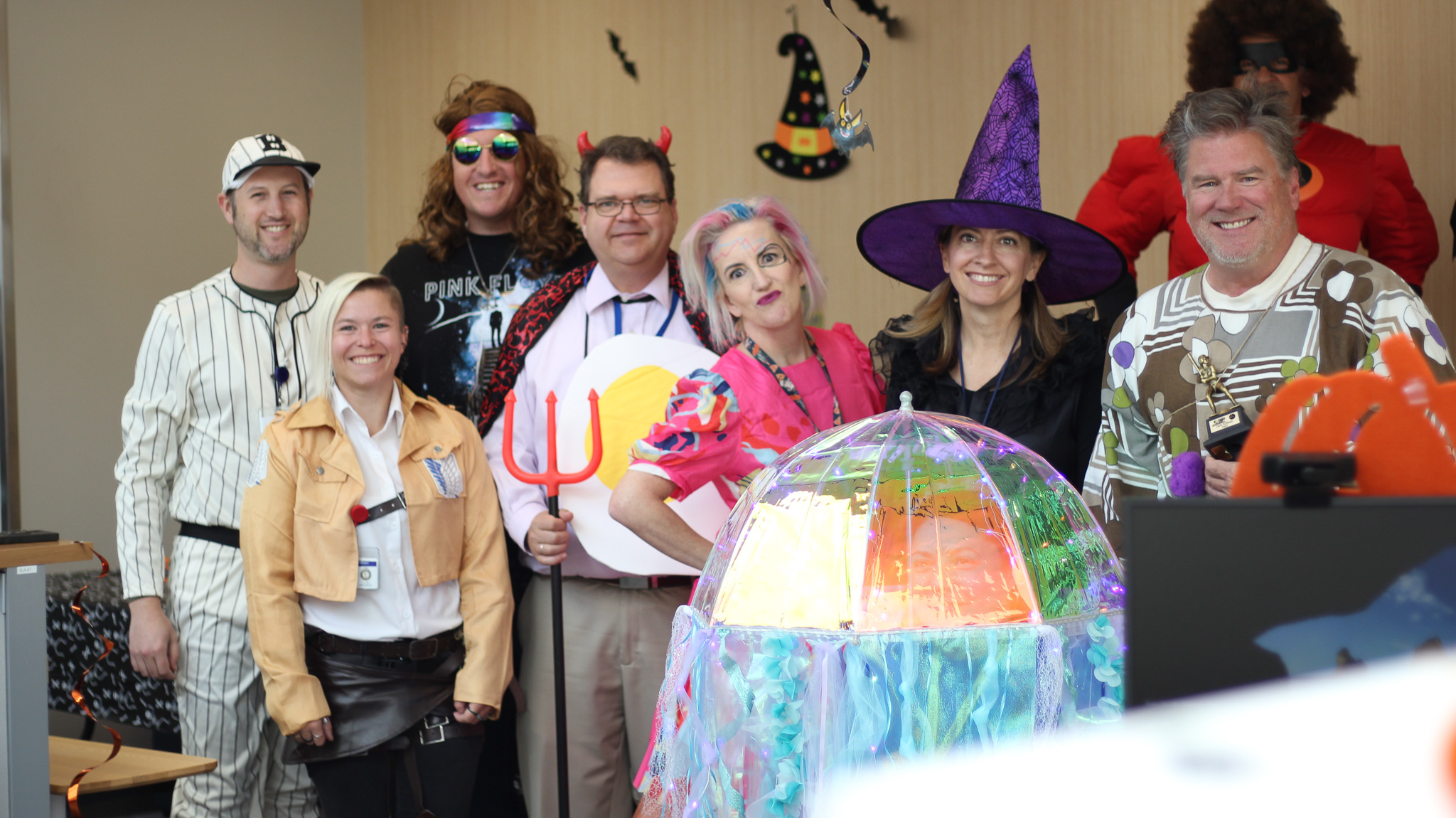 A group of people posing for a photo with a large balloon.