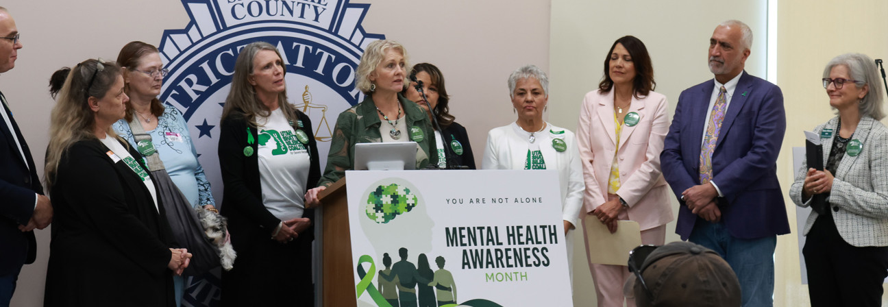 Saundra Santiago et al. standing in front of a sign.