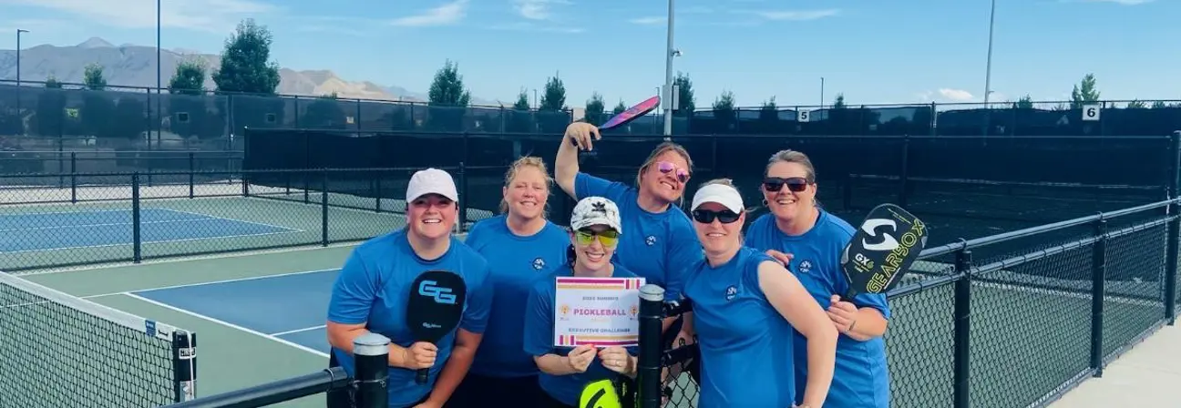 A group of people posing for a photo with a tennis racket.