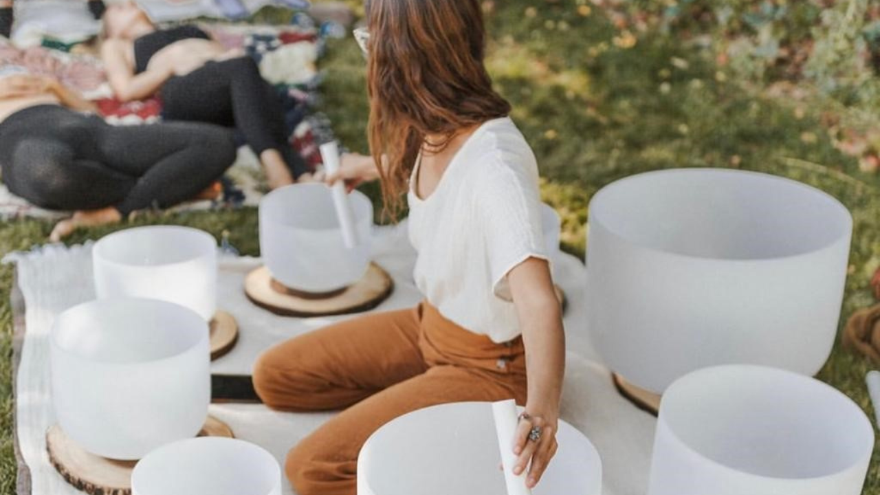 A person sitting at a table with a group of white cups.