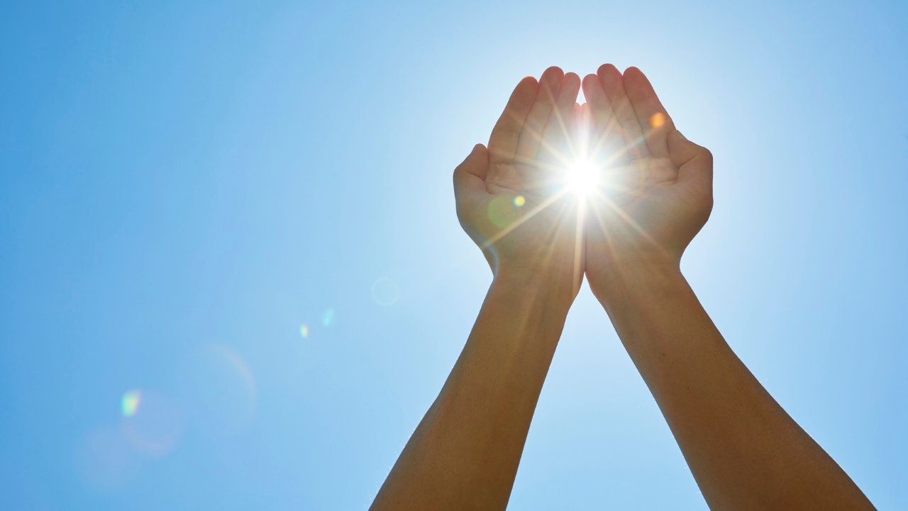 A hand holding a glowing light.