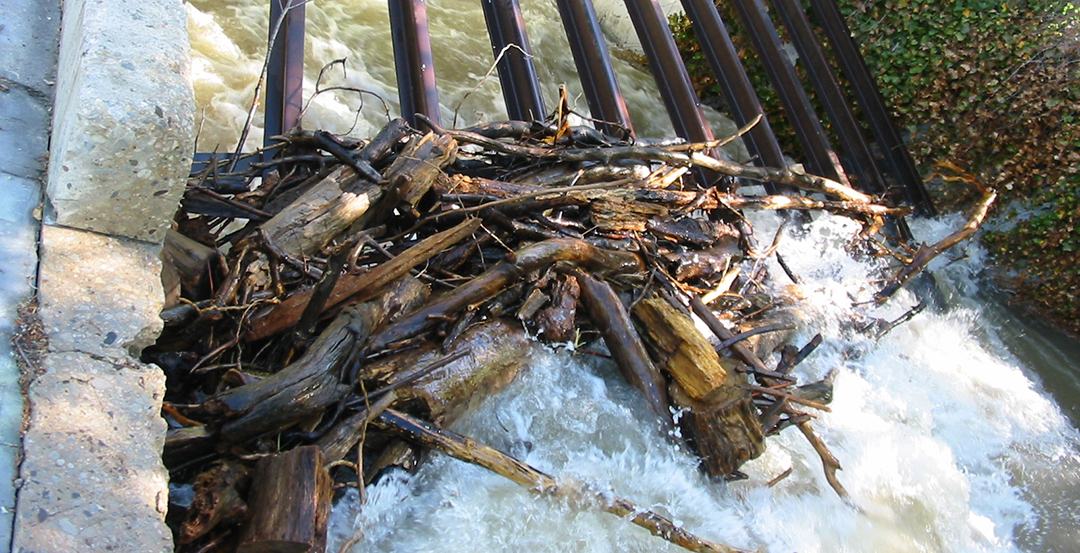 A pile of wood next to a water fall.