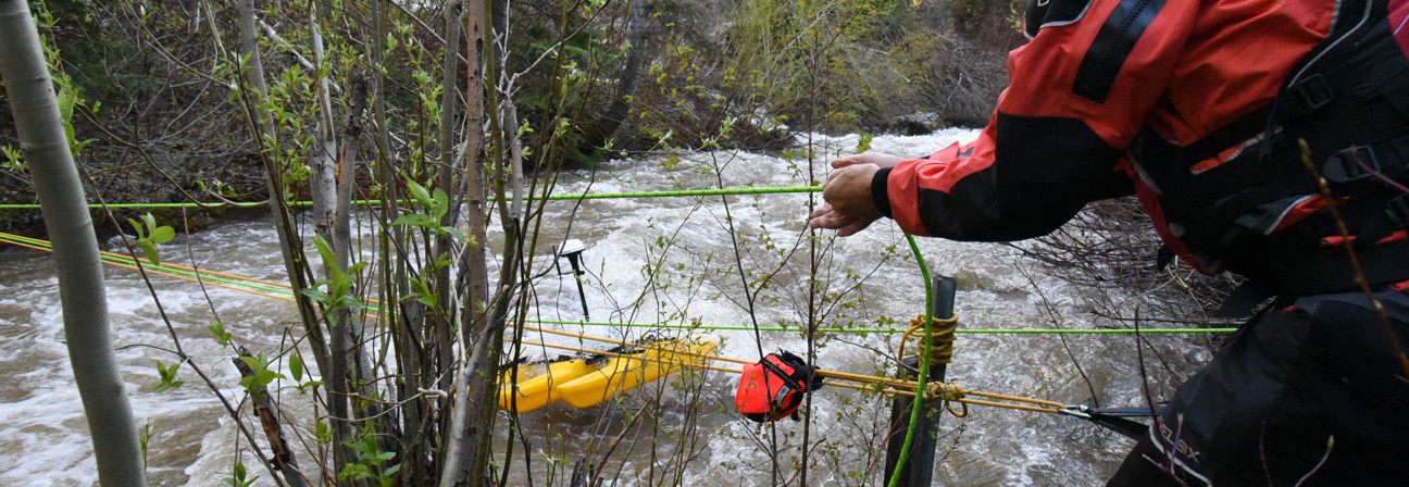 A man holding a cable and sampling water.