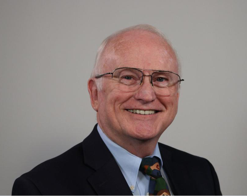 A man wearing glasses and a suit.