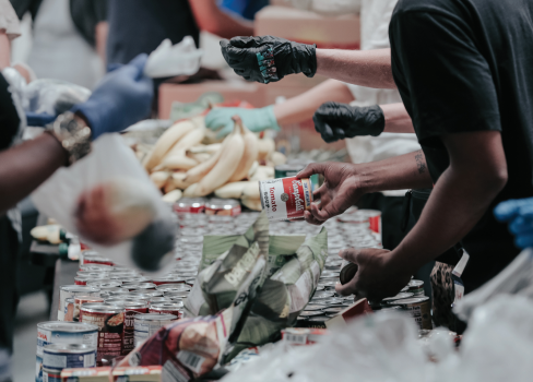A group of people putting food in a pile.