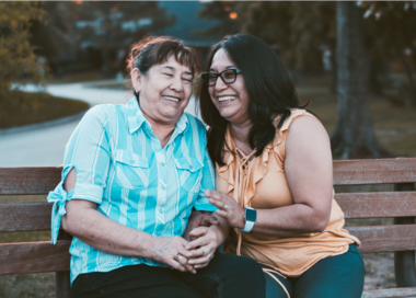 A man and a woman sitting on a bench.