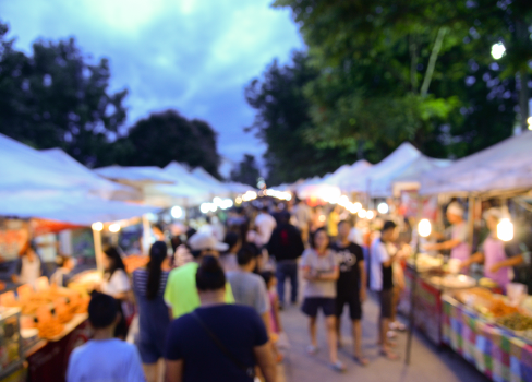 A group of people walking around a market.