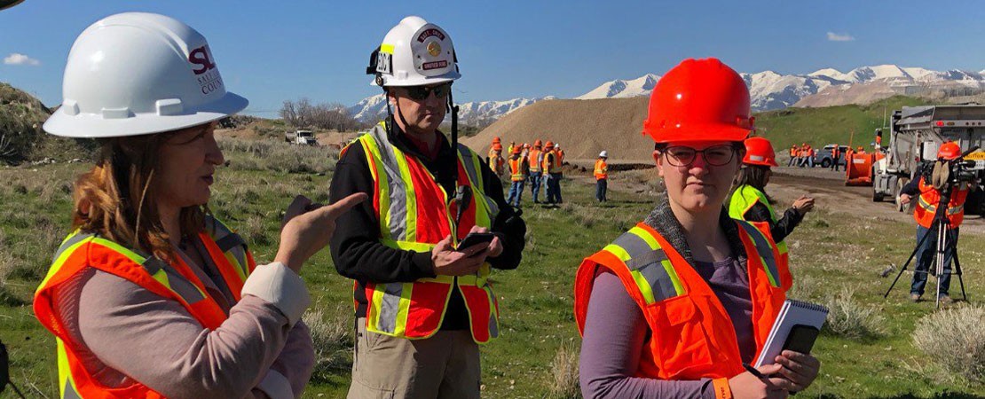 Mayor Wilson and two other people wearing hard hats at a work site outdoors.