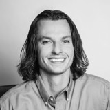 A person with long hair smiling.