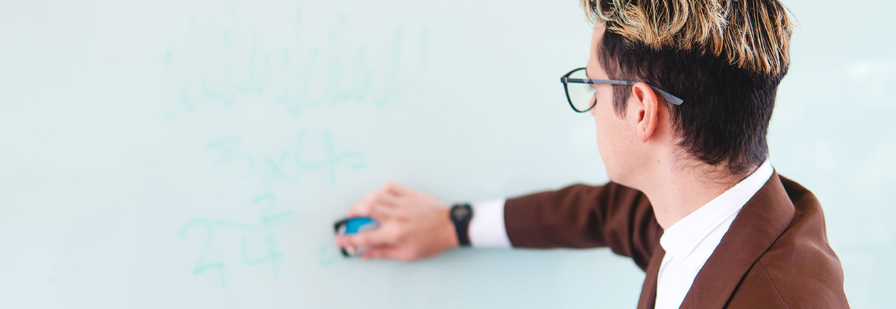 A man writing on a whiteboard.