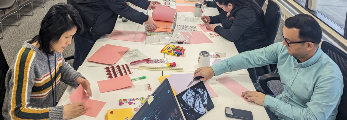 A group of people sitting around a table with papers and a laptop.