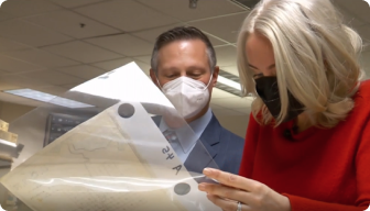A man and a woman looking at a model of a space ship.