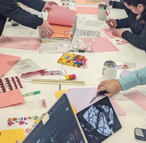 A group of people sitting around a table with papers and a laptop.