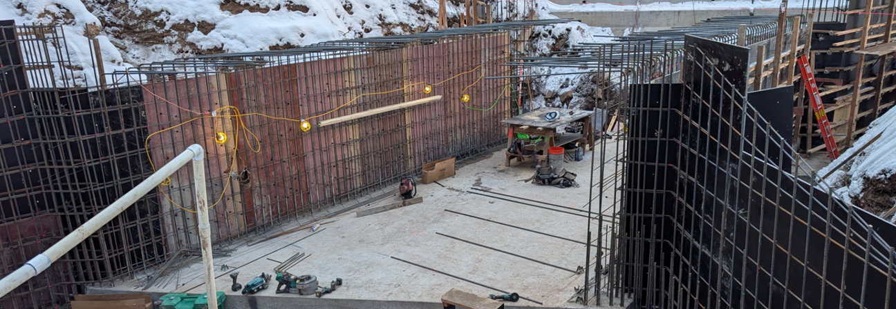 A construction site with a fence and snow.