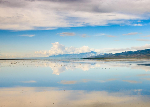 A body of water with mountains in the background.