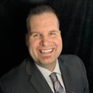 A man in a suit smiling.