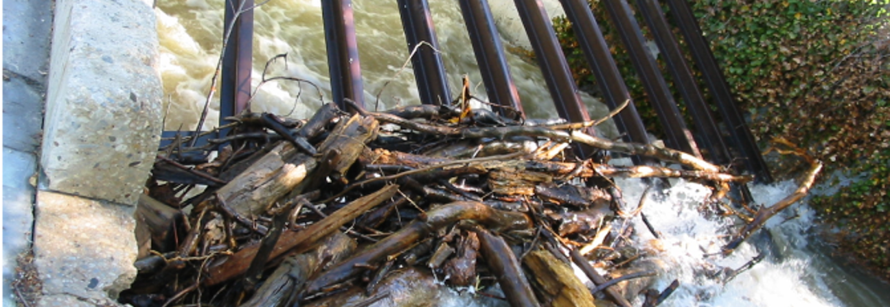 A pile of wood next to a water fall.