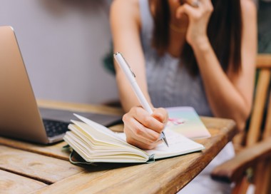 A woman writing on a piece of paper.