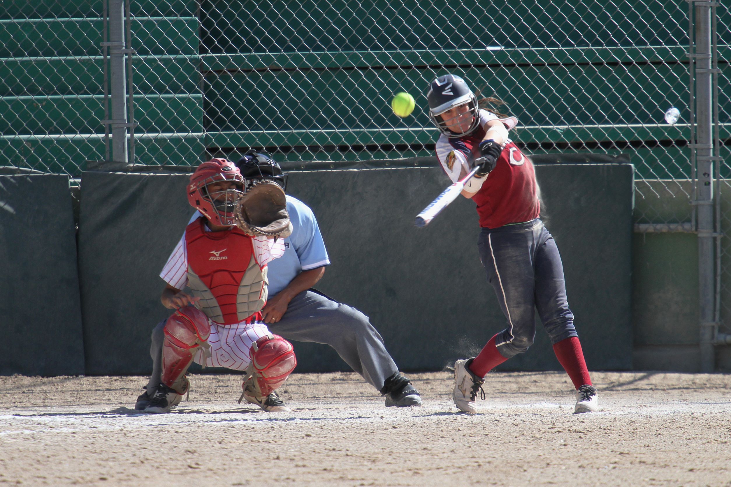 A baseball player hitting a ball with a bat.