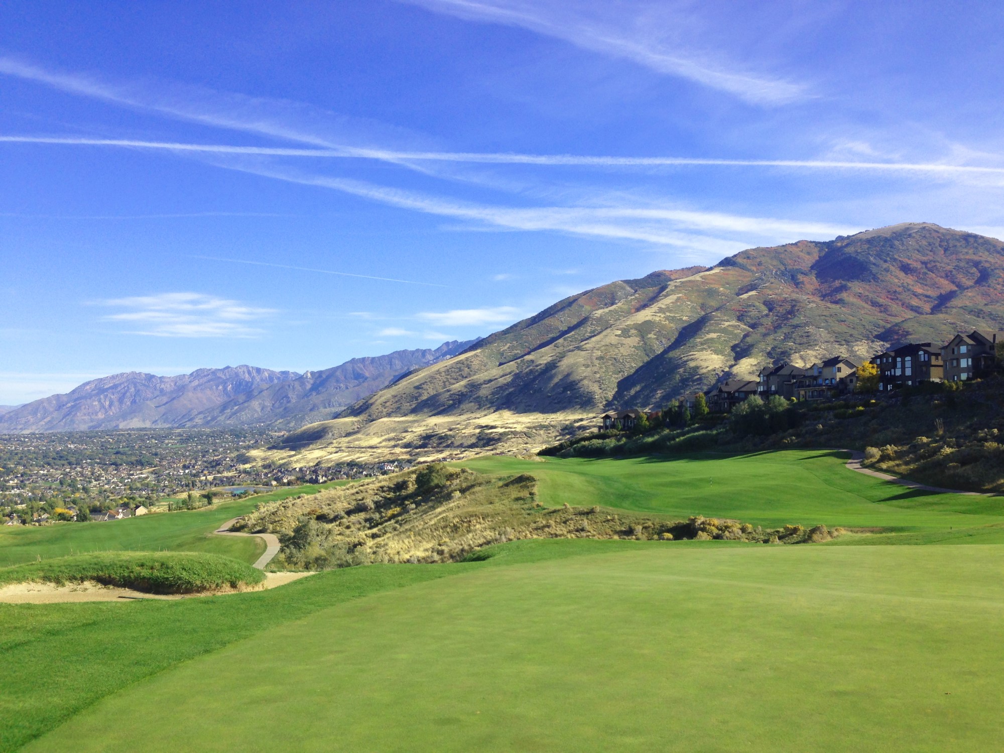 A green valley with a house on the hill.