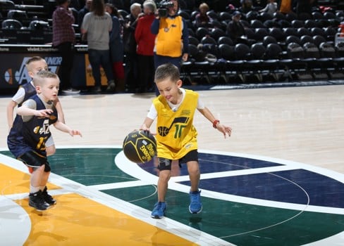 A couple of boys playing basketball.